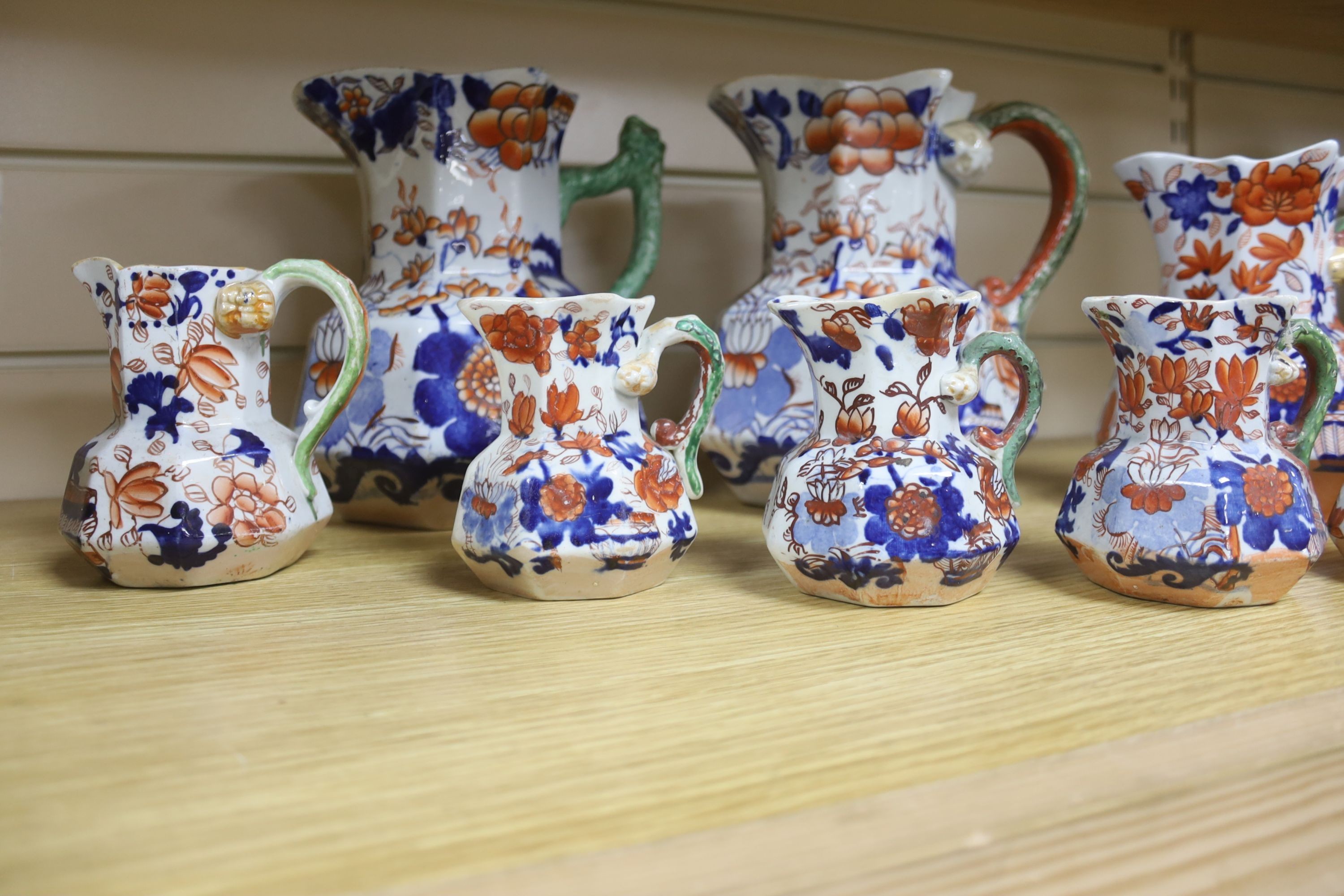 A graduated set of eight Mason's floral Imari pattern ironstone hydra jugs, c.1820-30, largest 19cm smallest 7cm and two other Mason’s ironstone jugs (10)
